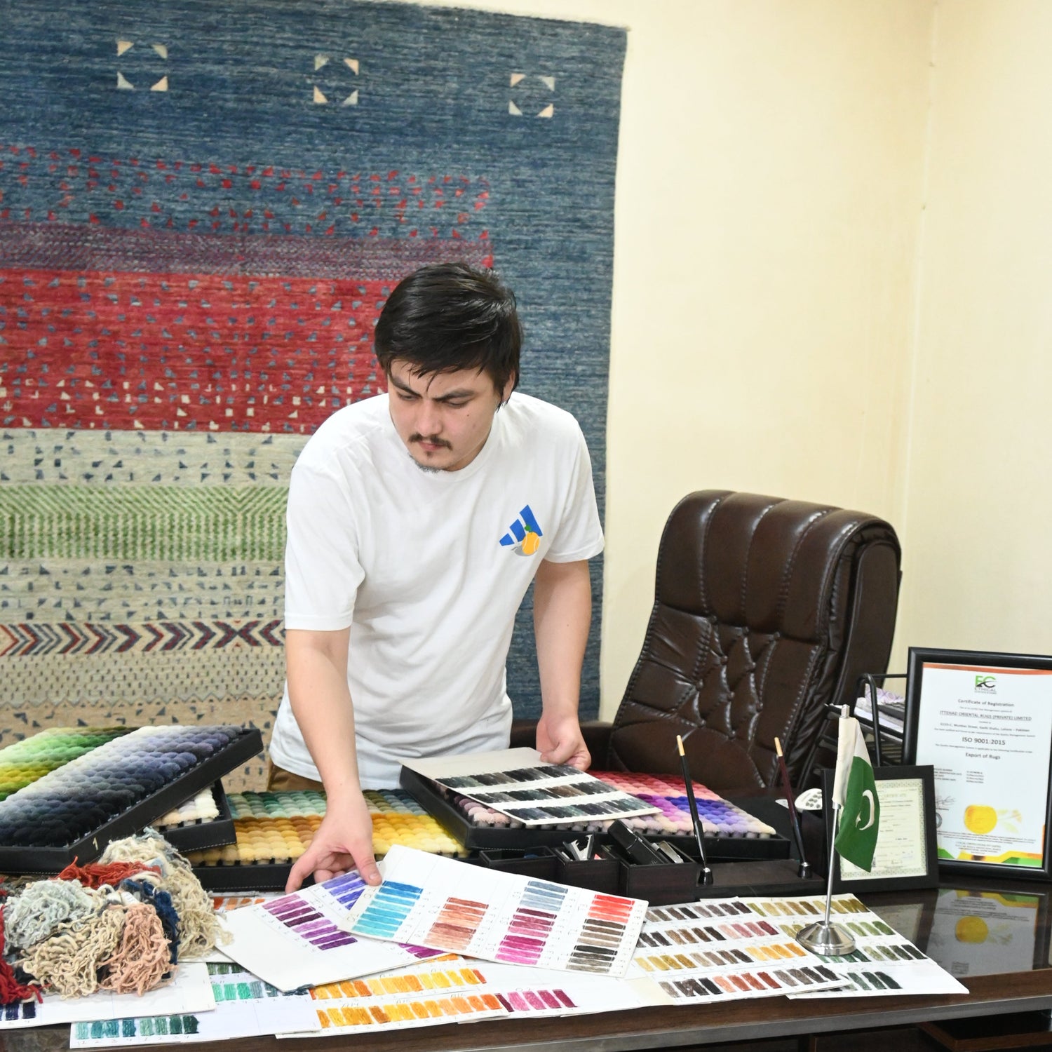 CEO in a room with a rug and color swatches, possibly selecting colors for a rug.